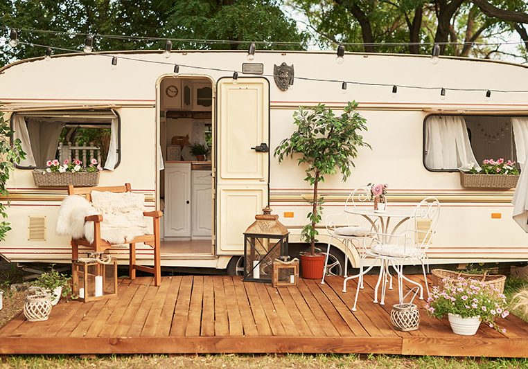 Van mobile home on green grass in summer at sunset, House on whe Van mobile home on green grass in summer at sunset, House on whe