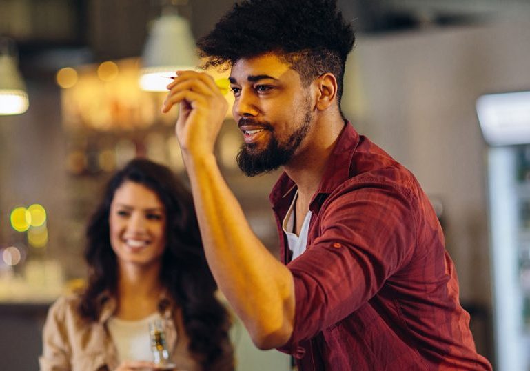 Cropped shot of friends playing darts