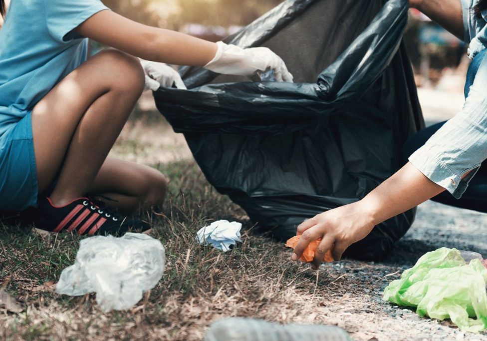 Mother and child help picking up trash at park